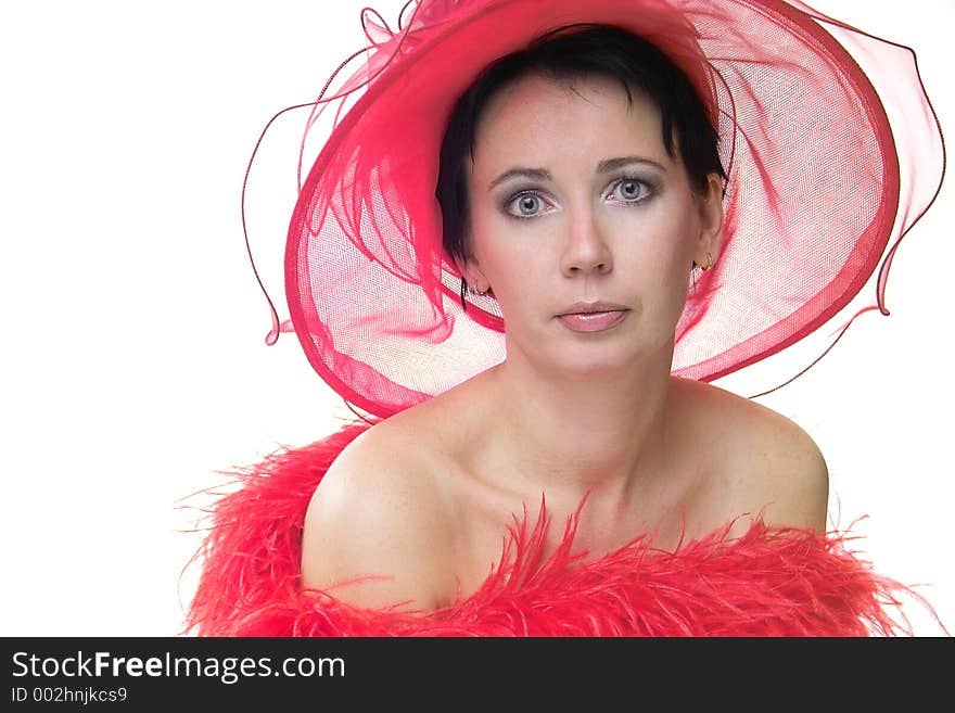 Portrait of a beautiful young woman wearing a red hat and feathered red boa over naked shoulders. Portrait of a beautiful young woman wearing a red hat and feathered red boa over naked shoulders