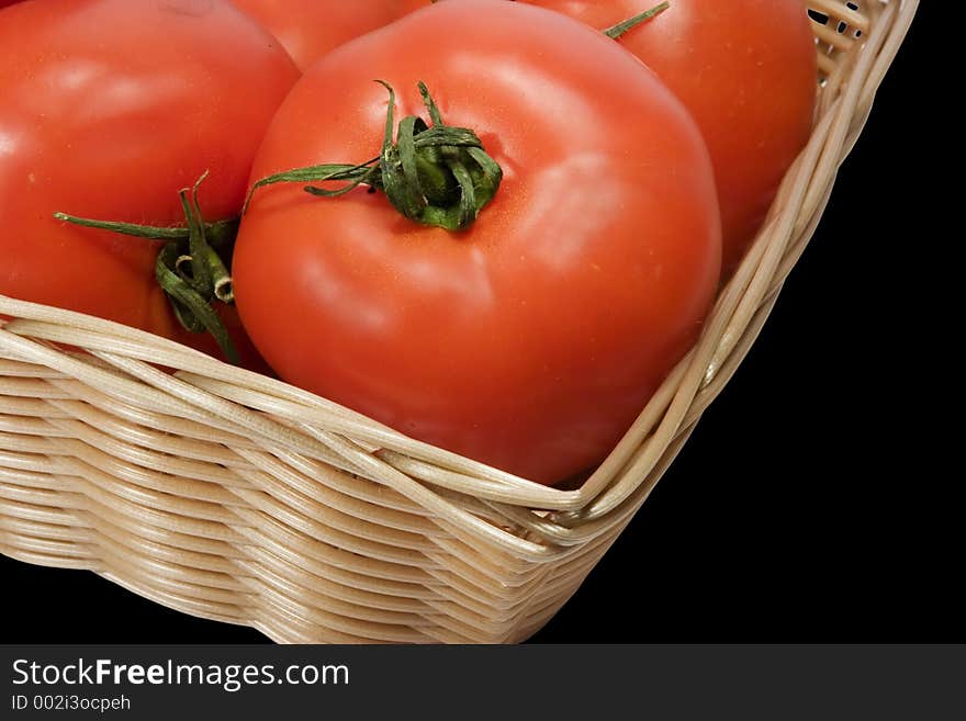 Basket with tomatoes on black background with clipping path