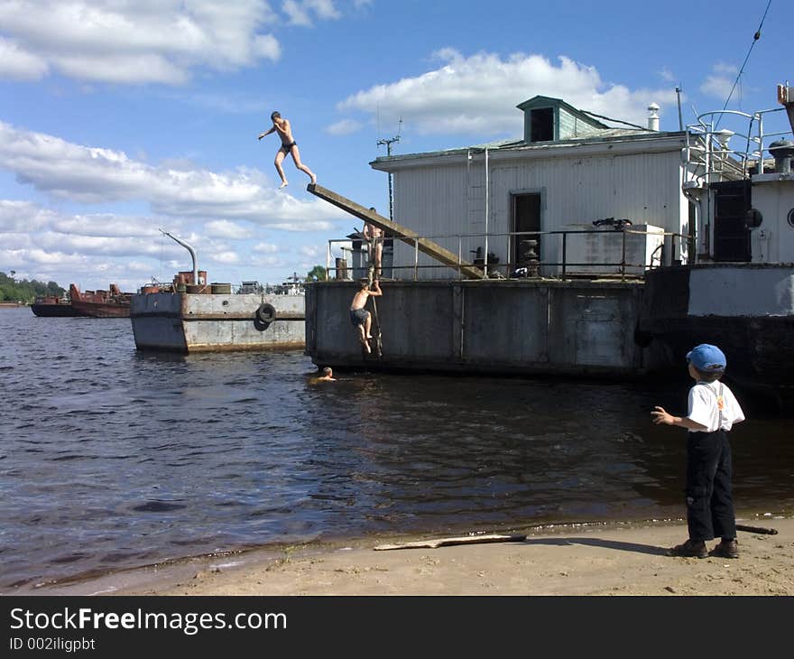 Children are diving into the river from the landing-stage