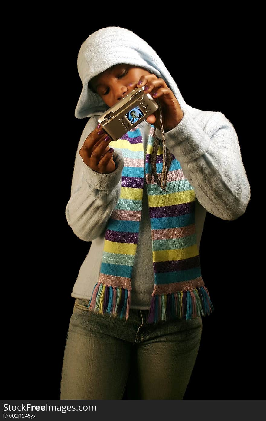 A teenage girl taking a self portrait. Isolated on a black background. A teenage girl taking a self portrait. Isolated on a black background.