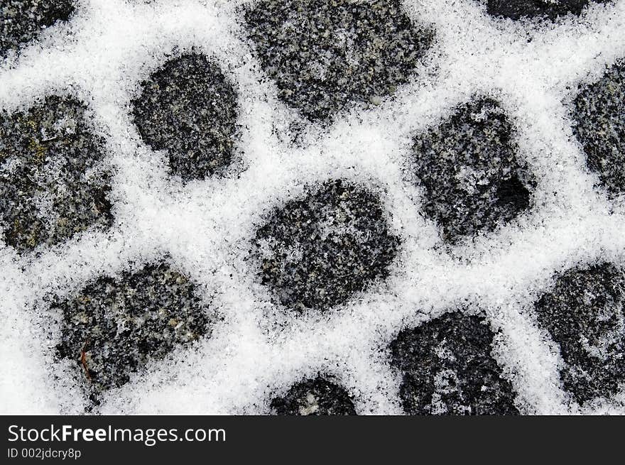 Snow filled granite pavement gaps make a pattern on the ground. Snow filled granite pavement gaps make a pattern on the ground