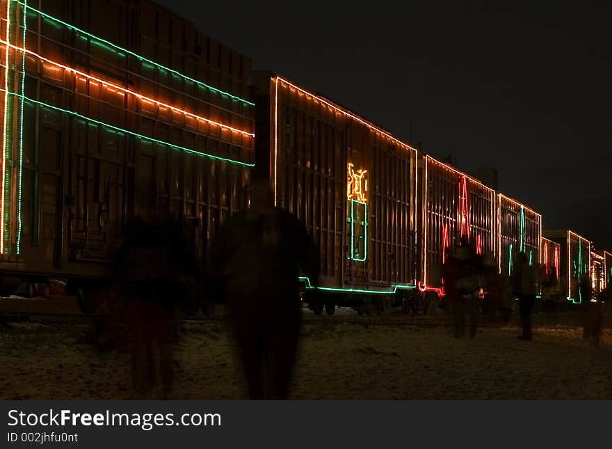 Decorated rail cars with motion-blurred silhouette of people walking past. Decorated rail cars with motion-blurred silhouette of people walking past