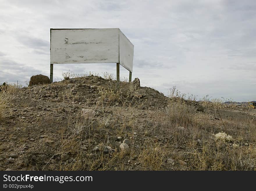 Blank wood double-faced sign in desert overlooking highway. Blank wood double-faced sign in desert overlooking highway.