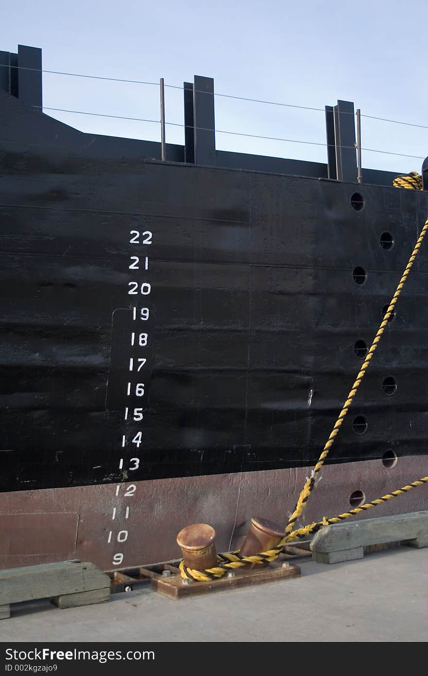 Port side of a freighter ship tied up to the dock in the harbor of Galveston, Texas, showing the depth marks on the freshly-painted side. Port side of a freighter ship tied up to the dock in the harbor of Galveston, Texas, showing the depth marks on the freshly-painted side.