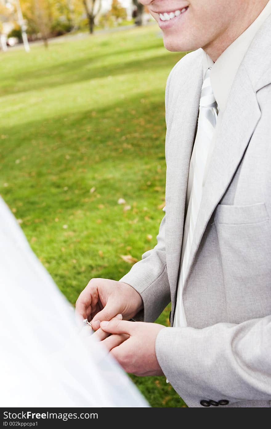 Happy man, places ring on bride's finger. Happy man, places ring on bride's finger