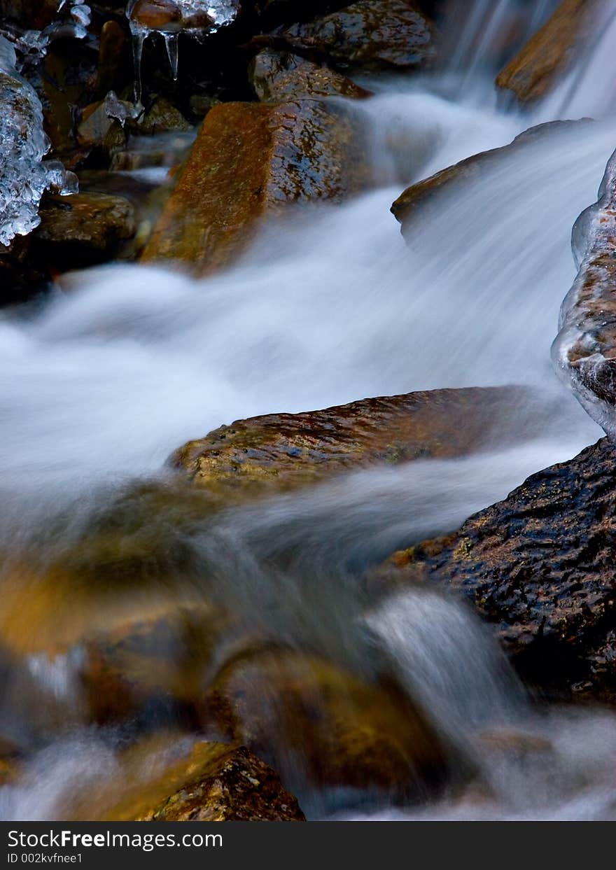 Water flows down from a mountain in early winter. Water flows down from a mountain in early winter.