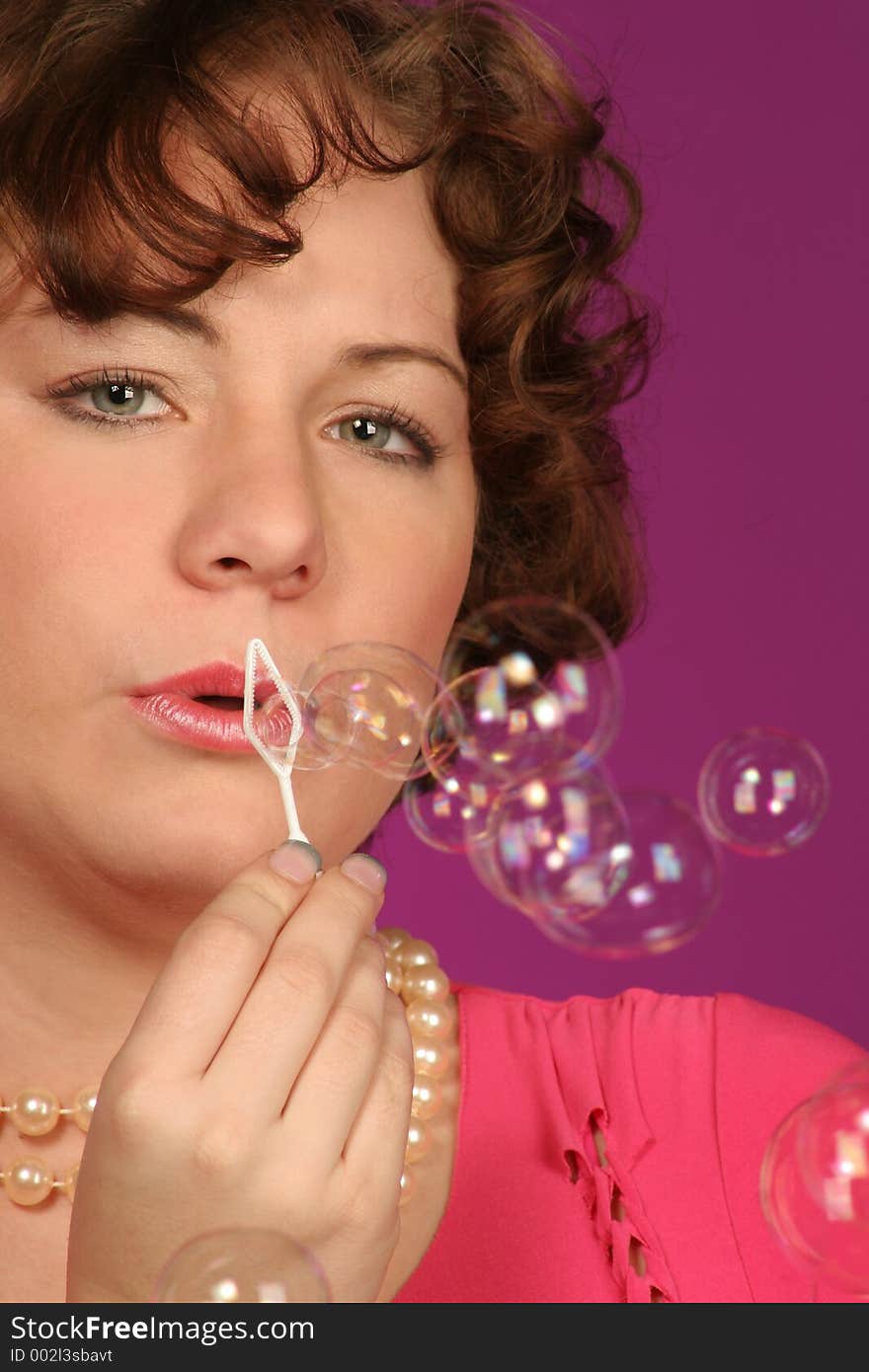 Close up of a girl who is still blowing bubbles