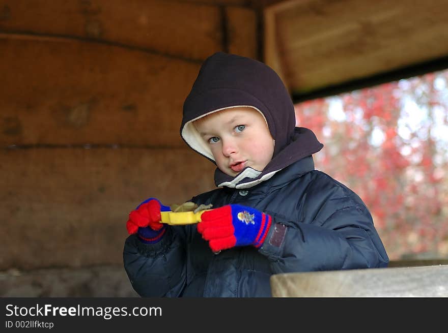 Boy child playing on playground in winter serving meal. Boy child playing on playground in winter serving meal