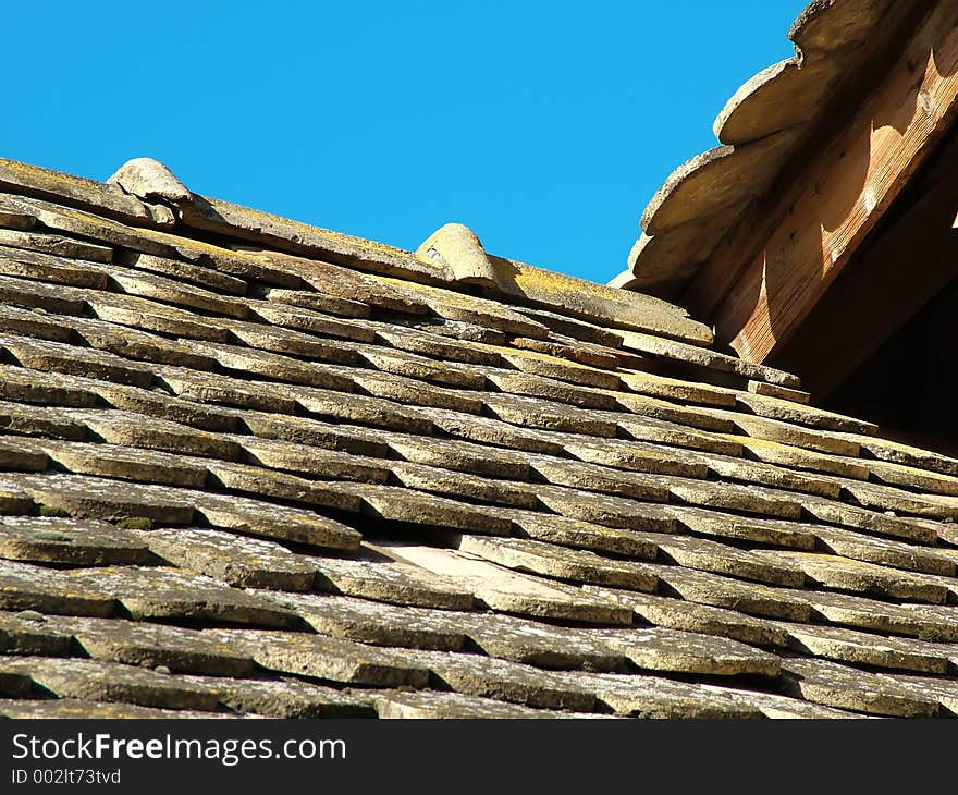 Diagonal composition of old rusty roofs. One roof one side, other roof opposite side. Sunny side roof. Roofs & sky. Diagonal composition of old rusty roofs. One roof one side, other roof opposite side. Sunny side roof. Roofs & sky