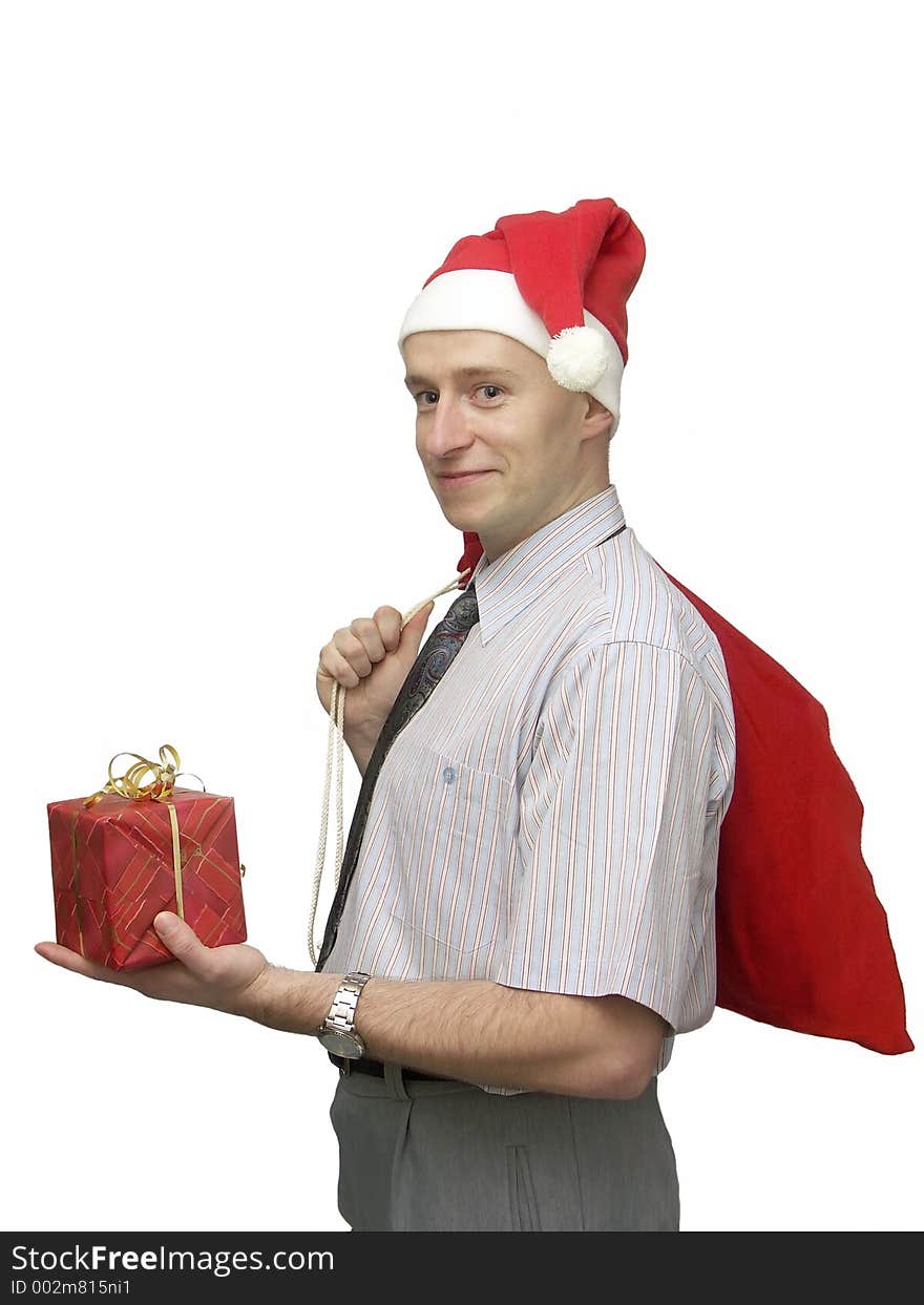 Young man wearing santa claus cap with red sack resting on his shoulder offering Christmas gift