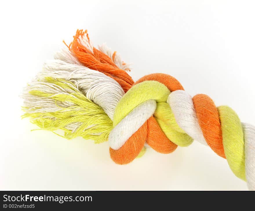 Knotted multi colored rope over white. Knotted multi colored rope over white