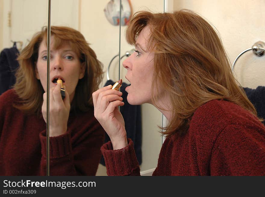 A woman applies makeup before going out for the night. A woman applies makeup before going out for the night.