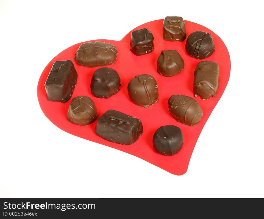 Large red heart with an assortment of chocolates over white. Large red heart with an assortment of chocolates over white