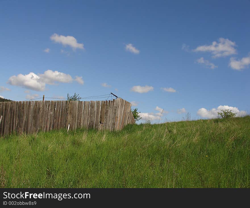 Idyllic view of a farm fence and a blue sky with a few clouds