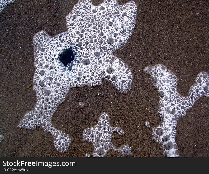 Sea foam on a sandy beach