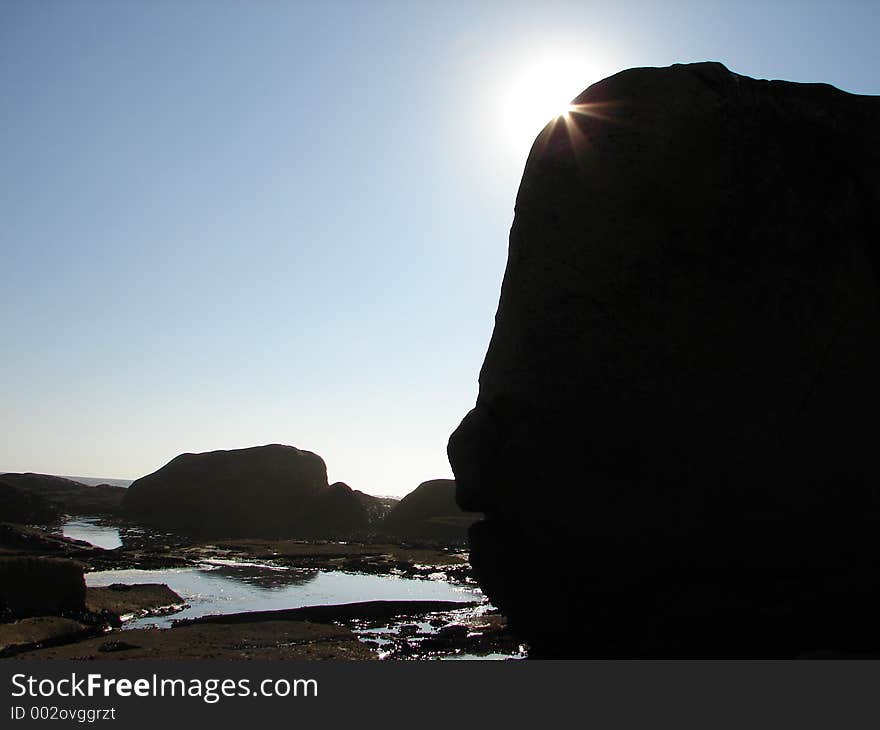 Big sea rock hiding the sun. Big sea rock hiding the sun