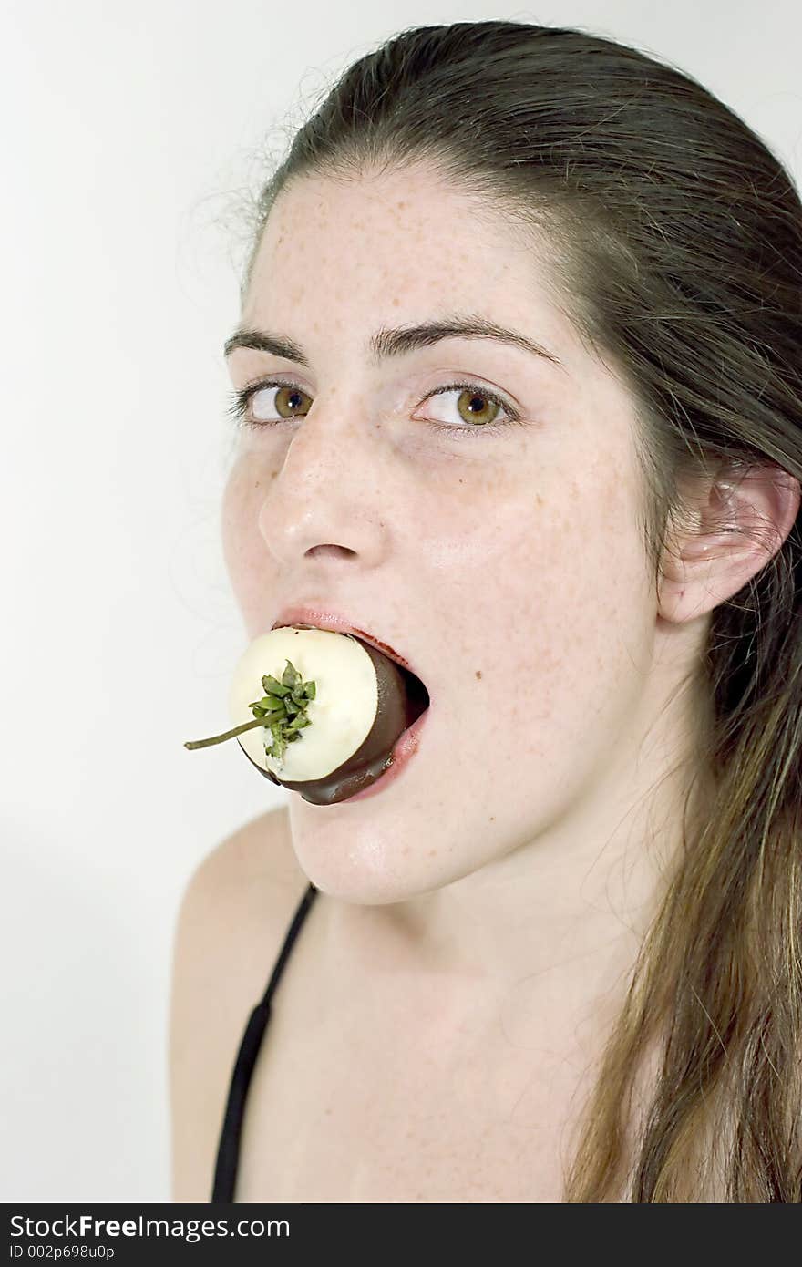 Young Attractive Woman Eating A Chocolate Covered Strawberry