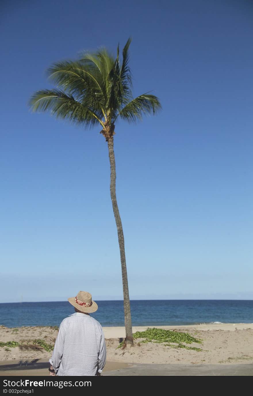 Man in a straw hat looking out to sea. Man in a straw hat looking out to sea