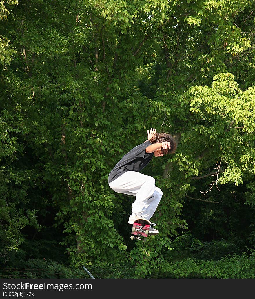 Skateboarder Jumping Near Trees