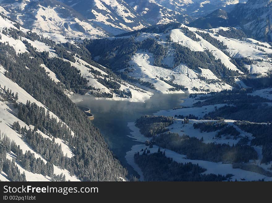 Lake And Dam In The Alps