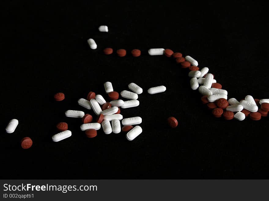 Pills laid out in a way that makes then look like they are waving around and spinning. Pills laid out in a way that makes then look like they are waving around and spinning.