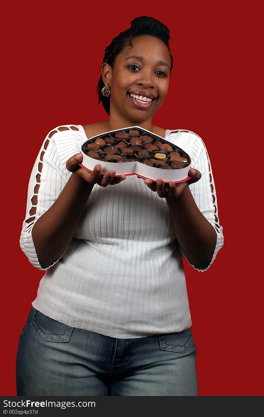 A pretty young woman holding a box of valentine candy.