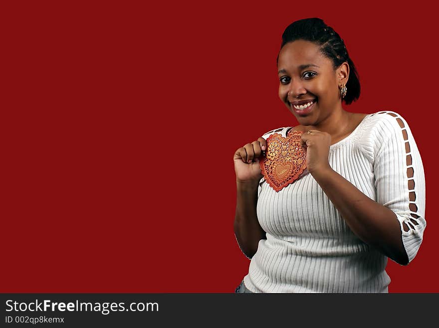 A pretty young woman holding a paper valentine.