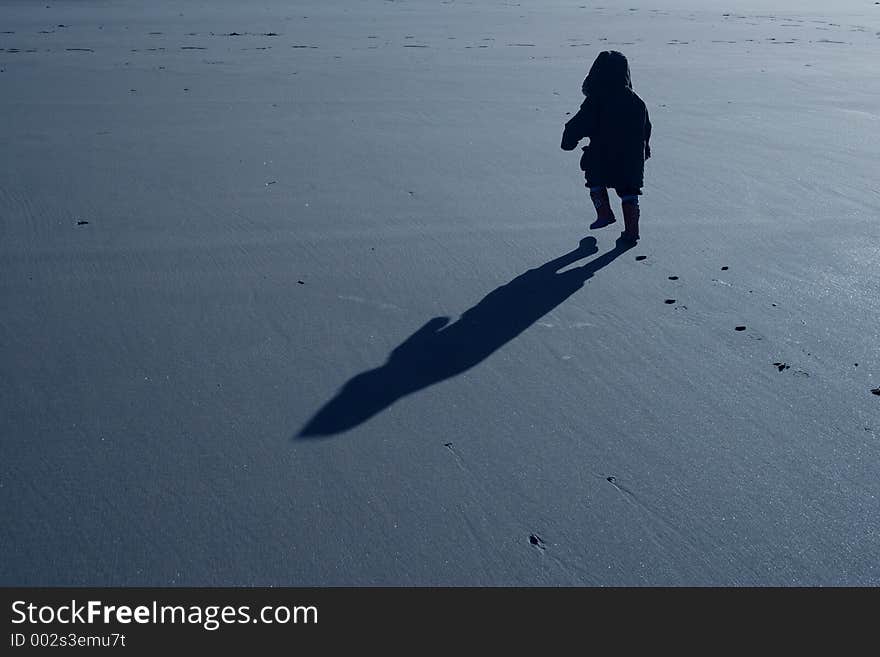 A young boy on a beach walking with purpose. A young boy on a beach walking with purpose.