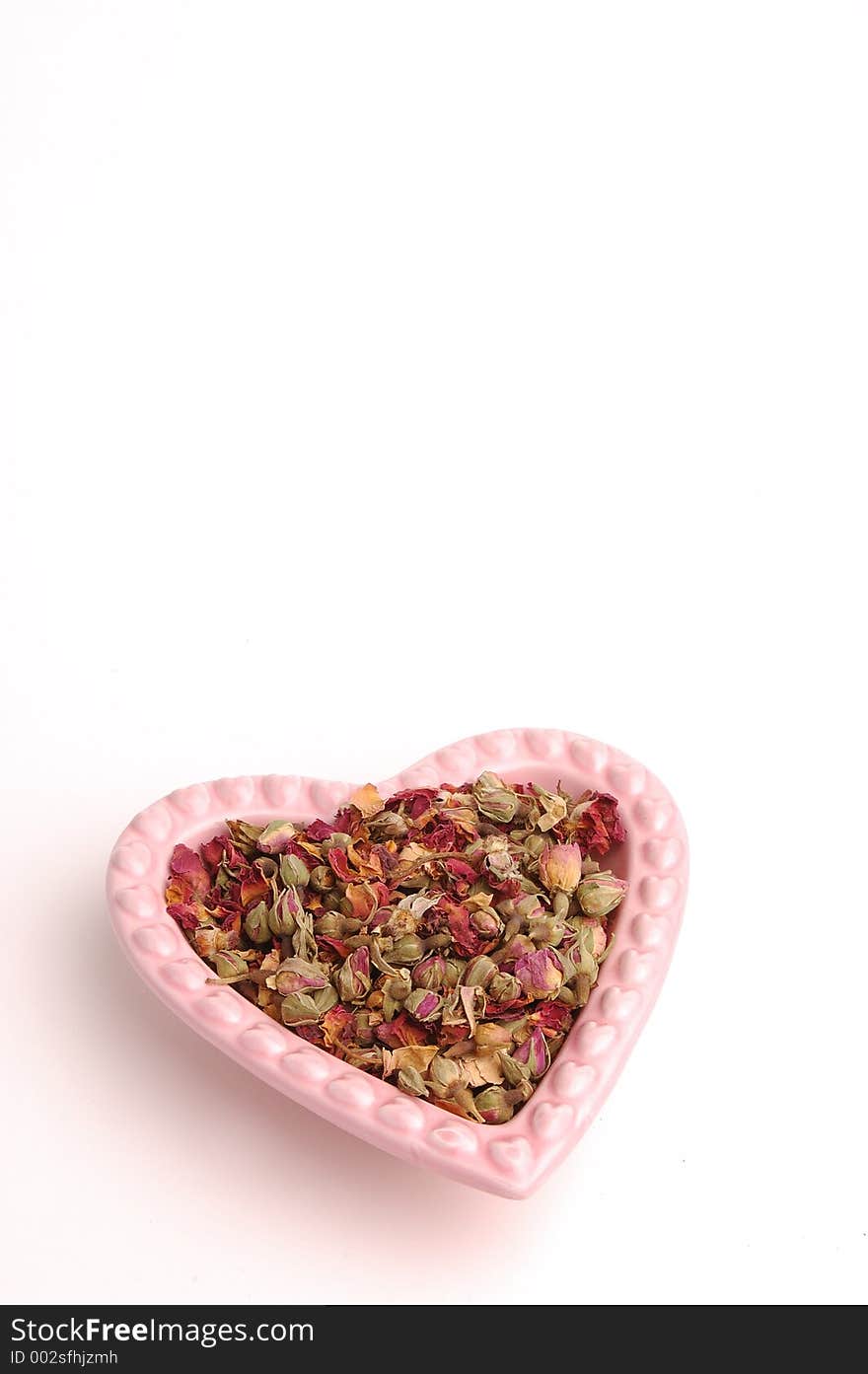 Rose buds in a heart shaped dish. Rose buds in a heart shaped dish