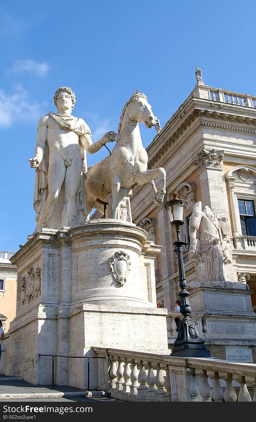 A statue of the mythological figure, Castor, and his horse outside an ornate building. A statue of the mythological figure, Castor, and his horse outside an ornate building.