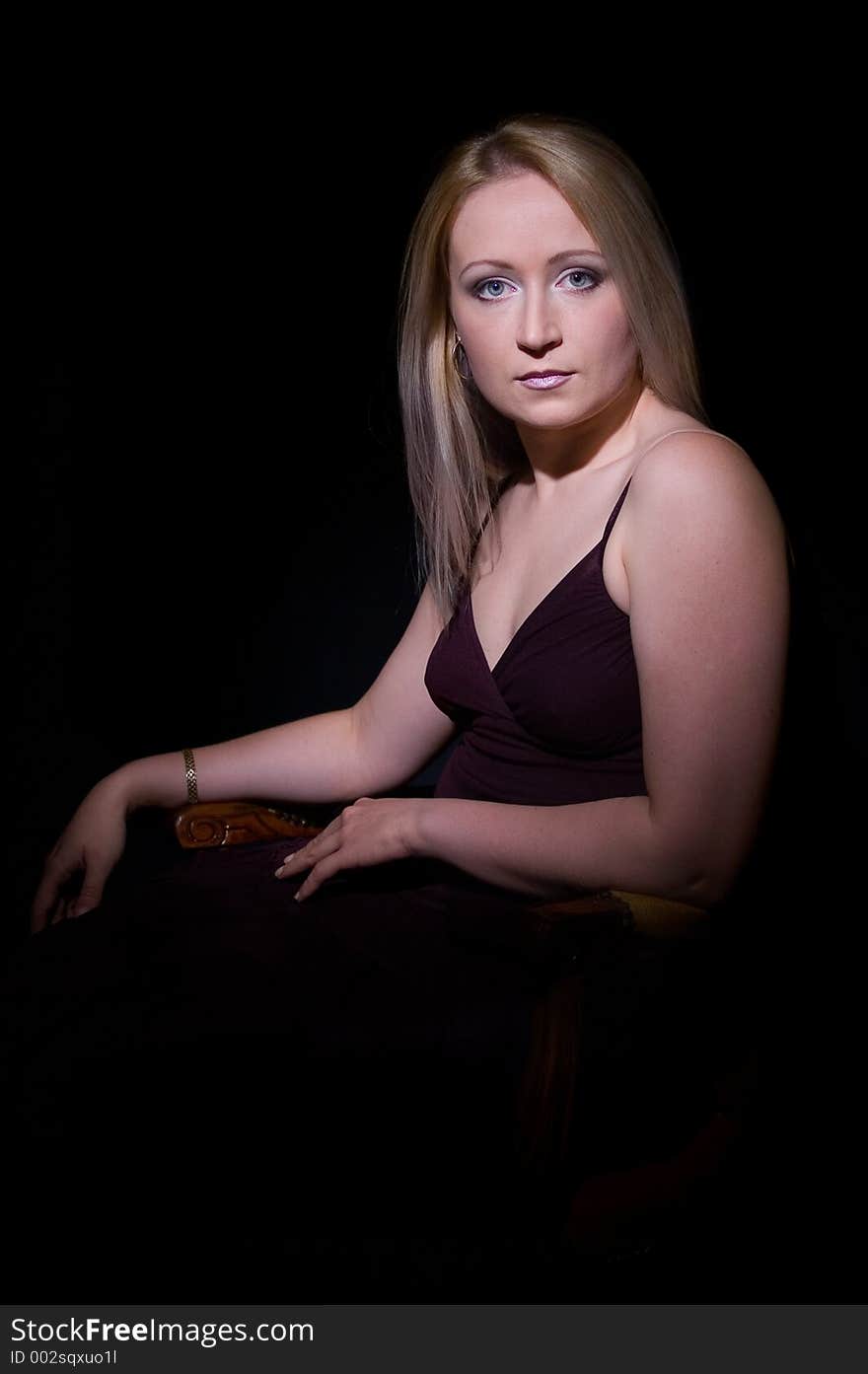 Attractive young woman in spot light on the black background. Attractive young woman in spot light on the black background