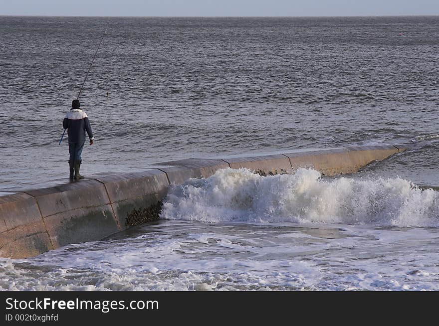 Man Fishing On Sea Wall