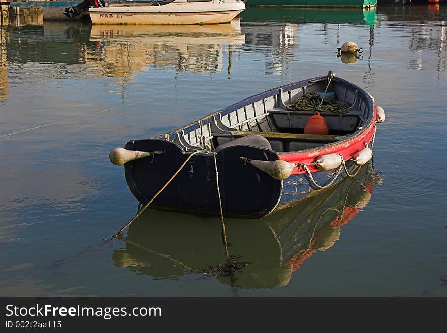 Old blue boat on water with reflection