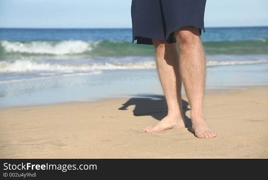 Man's legs as he walks on the beach. Man's legs as he walks on the beach