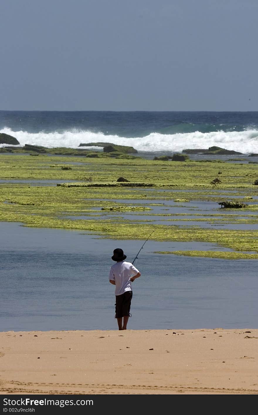 Young boy fishing from beach. Young boy fishing from beach