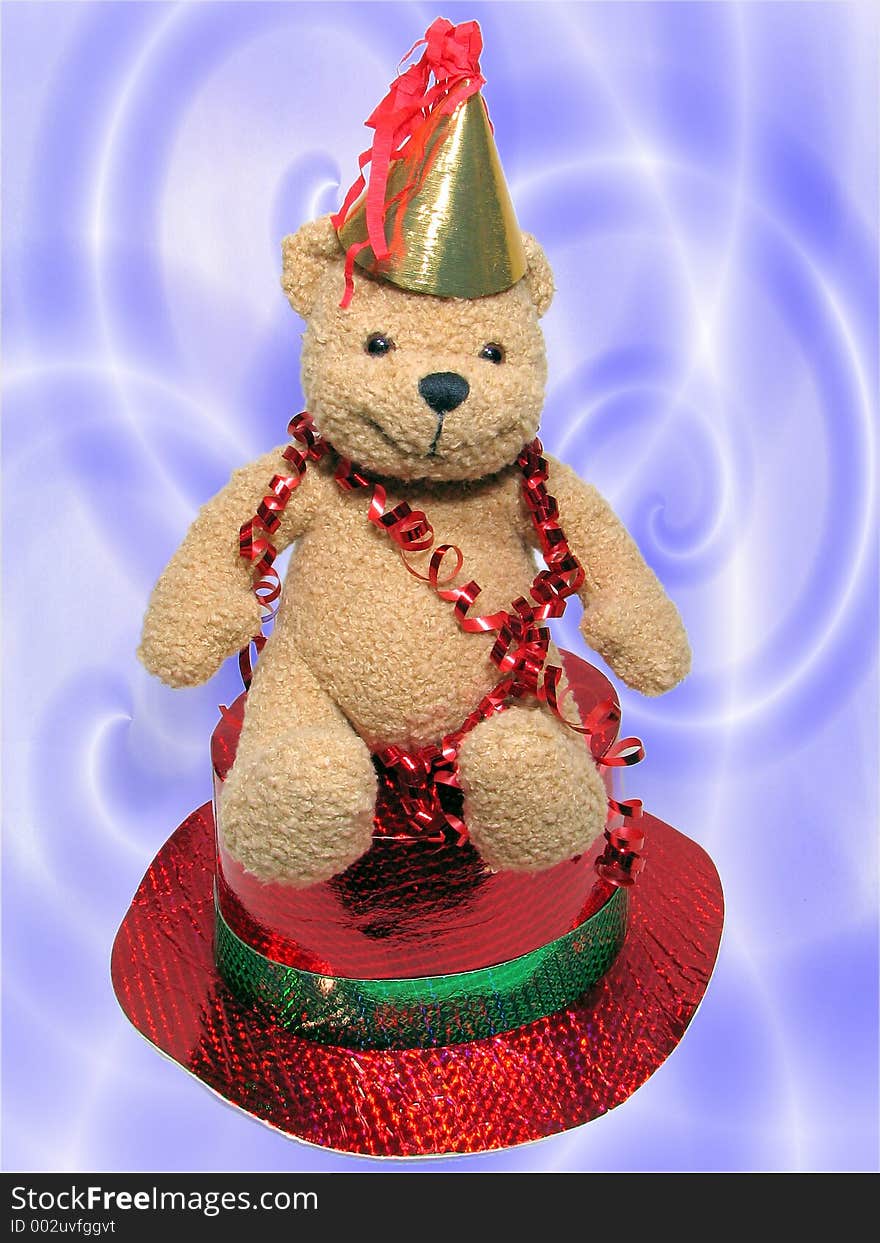 Teddy bear with streamer is sitting on a red hat. Teddy bear with streamer is sitting on a red hat.