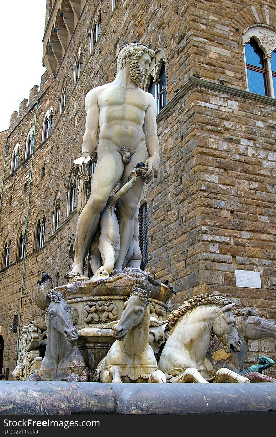 Closeup of classical Roman statue of nude man surrounded by horses.