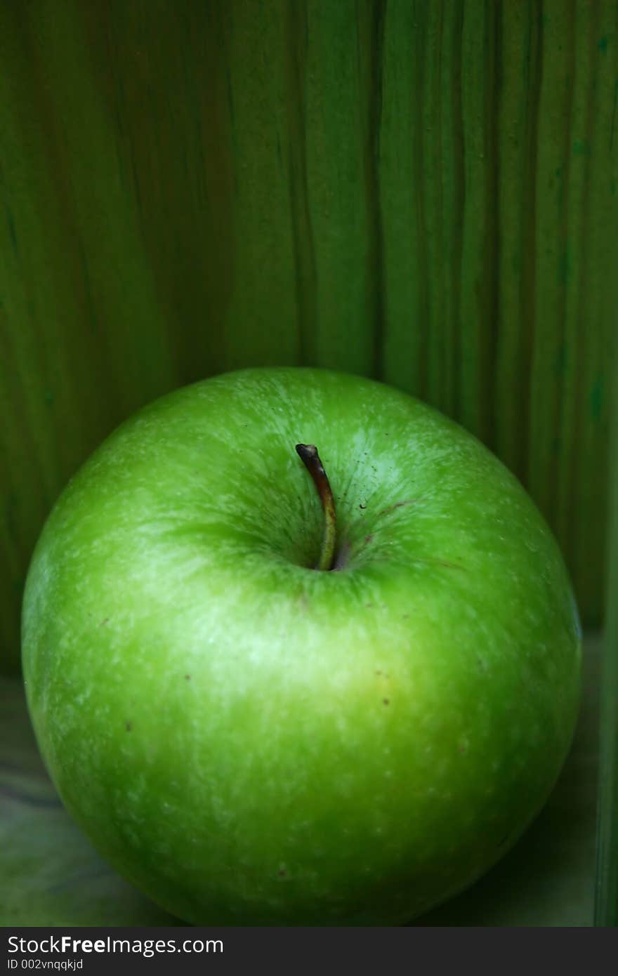 Green apple on a green background