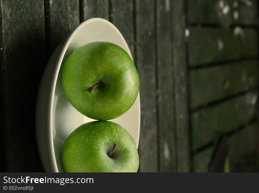 Green apples on a white plate