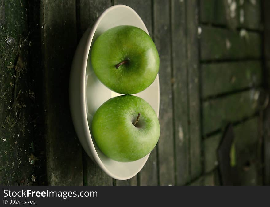 Green apples on a white plate