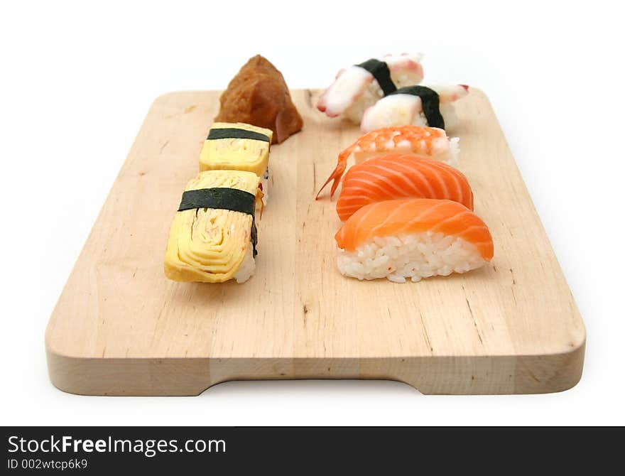 A selection of sushi served on a wooden surface board