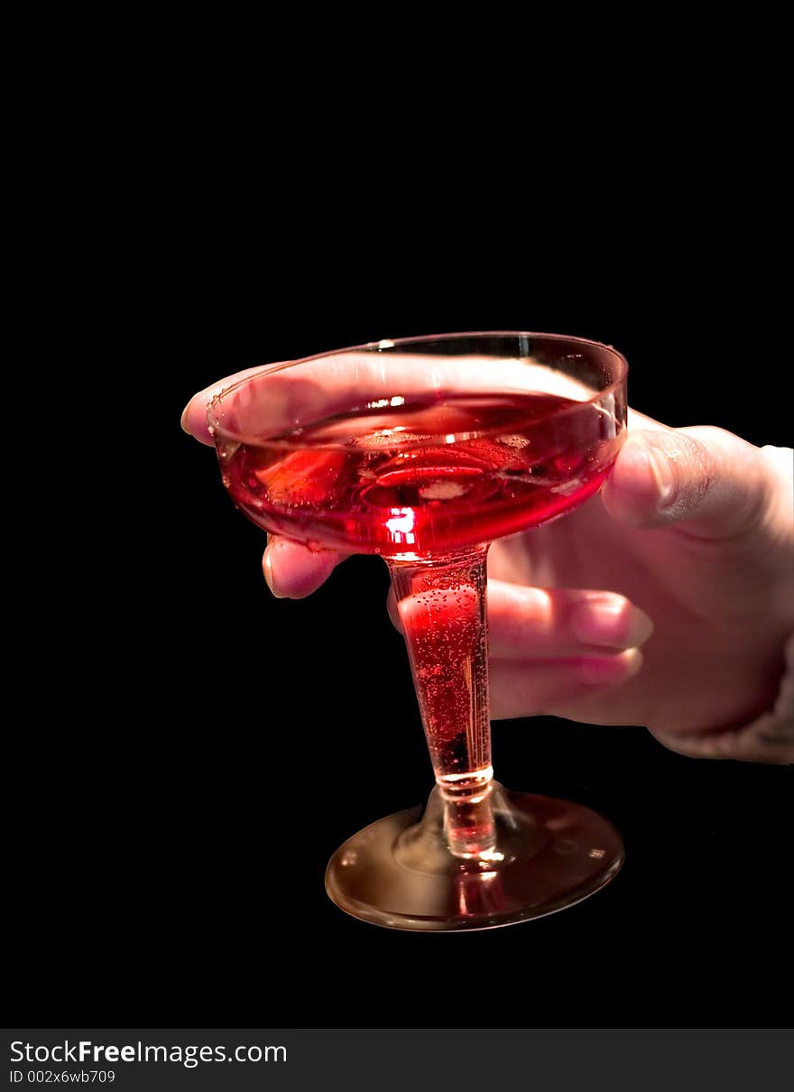 A glass of rose shampagne in hand isolated on black. A glass of rose shampagne in hand isolated on black