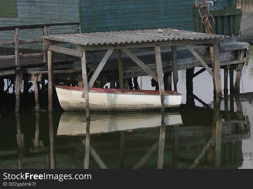 Small white boat under an old roof