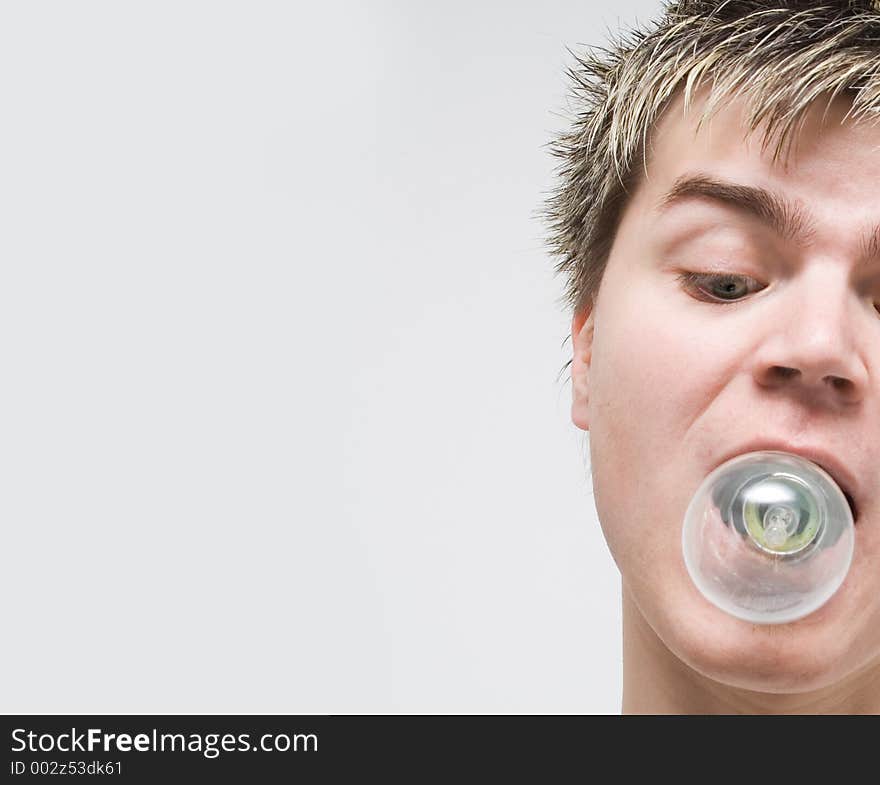 High Key - Portrait of a young man with a lightbulb in his mouth. High Key - Portrait of a young man with a lightbulb in his mouth