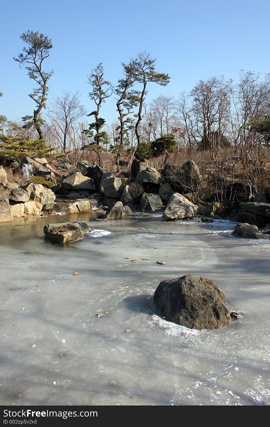 Pond frozen over with waterfall in the background. Pond frozen over with waterfall in the background