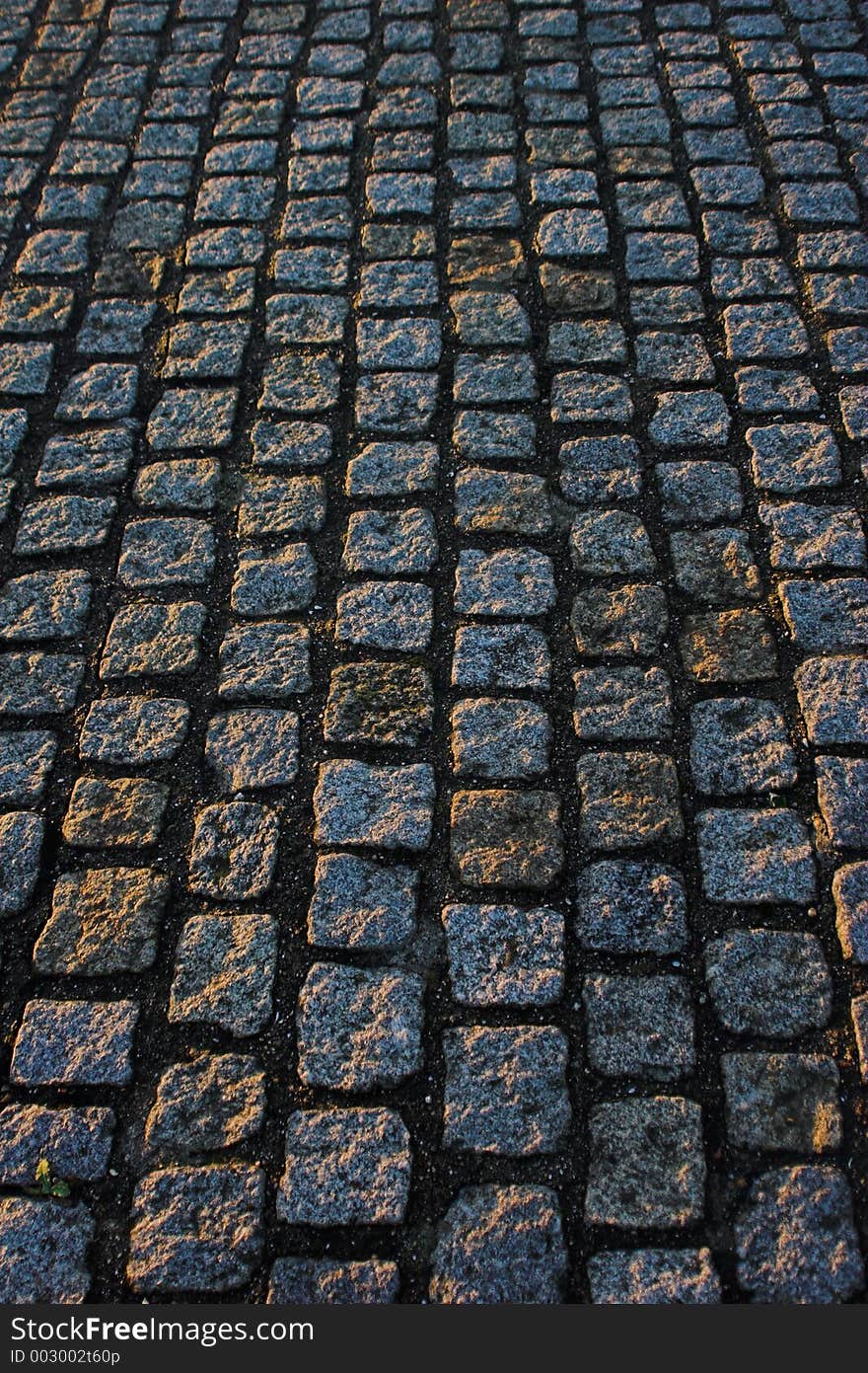 Cobble paving blocks running from top to bottom of frame.