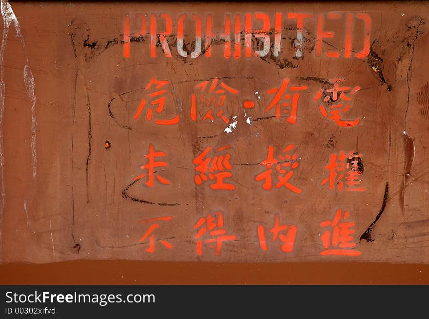 Painted sign on a rusty industrial door in Chinese characters and English. Painted sign on a rusty industrial door in Chinese characters and English