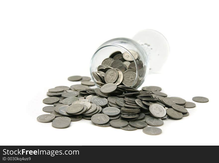 Wineglass with coins poured out over a white background. Wineglass with coins poured out over a white background