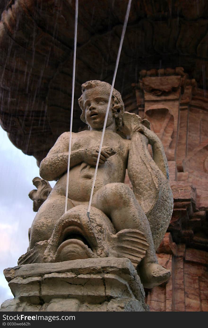 This child in stone sits on what seemed to be a fish. This was one of several details on this big fountain in the Italian city. This child in stone sits on what seemed to be a fish. This was one of several details on this big fountain in the Italian city.