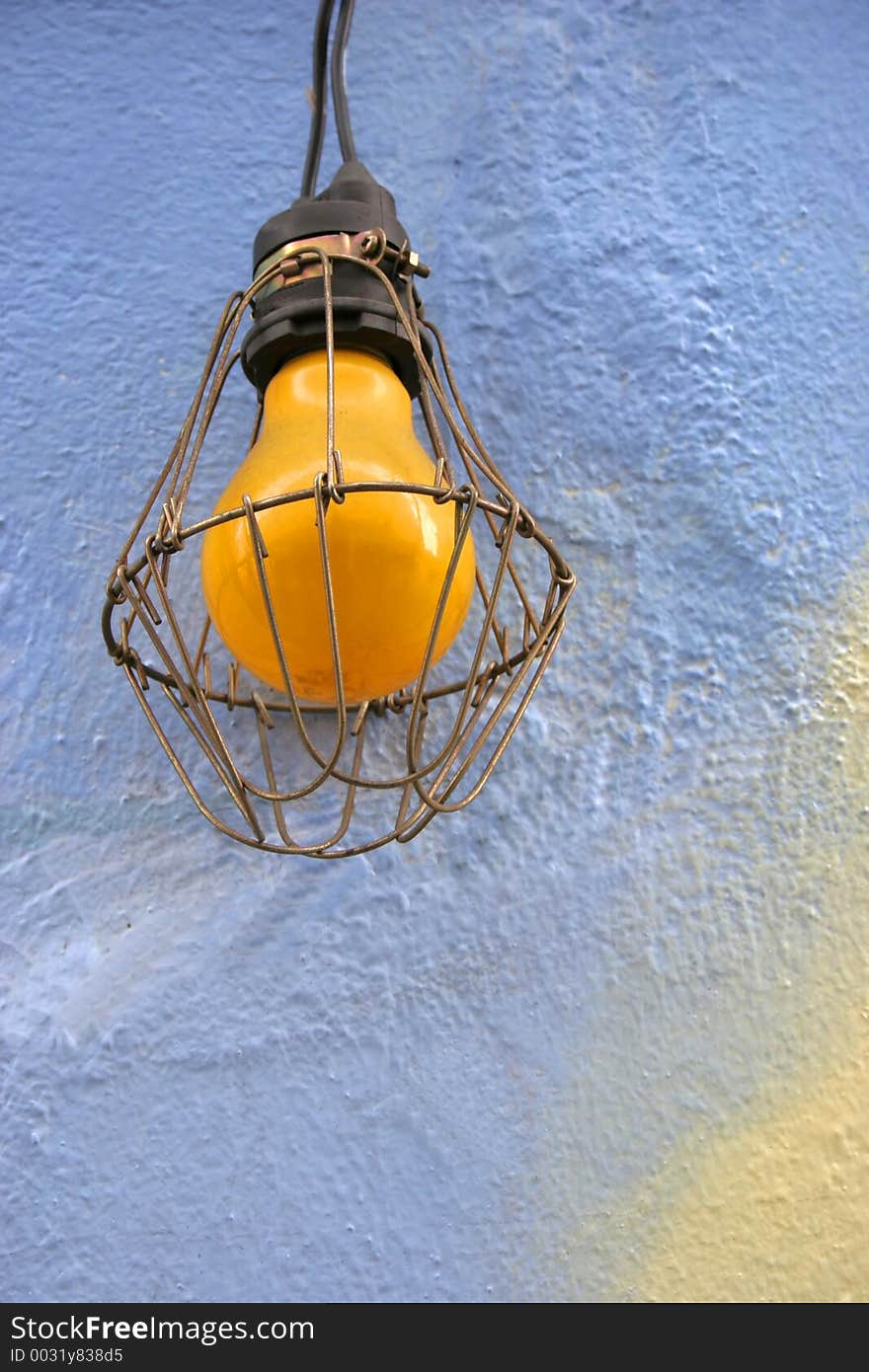 Yellow light bulb against a blue background - copy space. Yellow light bulb against a blue background - copy space